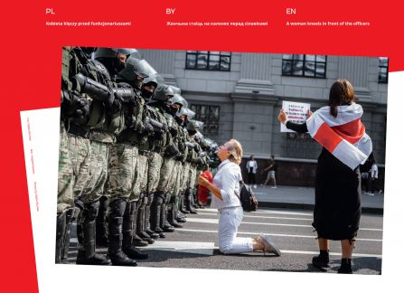 Fotografia z wystawy Białoruś. droga do wolności. kobieta klęczy przed szeregiem żołnierzy. obok kobieta owinięta historyczną flagą białoruską.